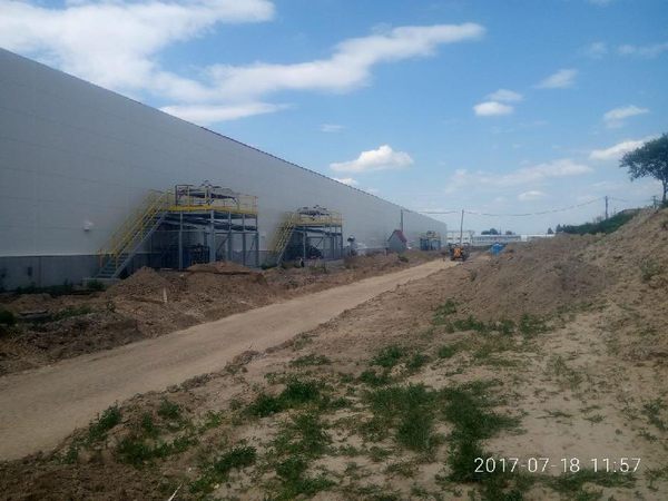 Außenansicht einer Industriehalle mit Arbeitsbühne